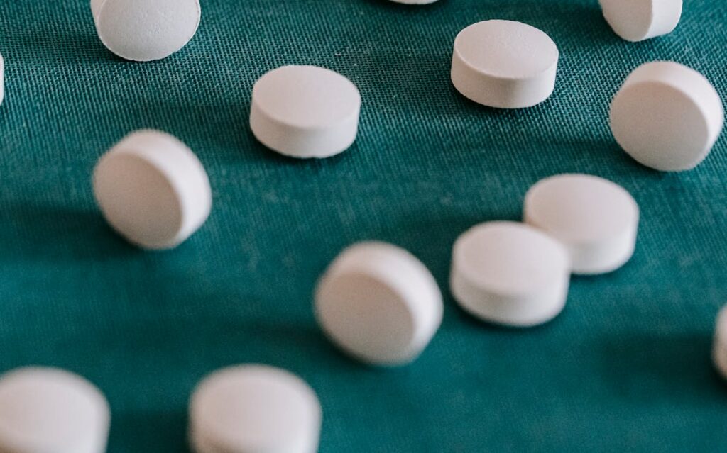 White tablets scattered on teal fabric.